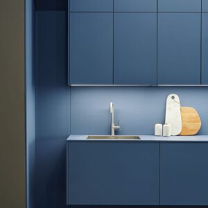 Wie aus einem Guss wirken Wand und Küche in Blau. Das Schichtstoff-Material heißt „SensiQ“ und ist von der Marke Systemo. Sie gehört zur Schüller Gruppe. 