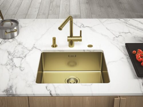 Das helle Gold mit Holz und Marmor ist ein Blickfang. Die Armatur aus der Serie „Mythos Masterpiece“ hat eine kratzresistente Oberfläche und ist hygienisch. Von Franke.