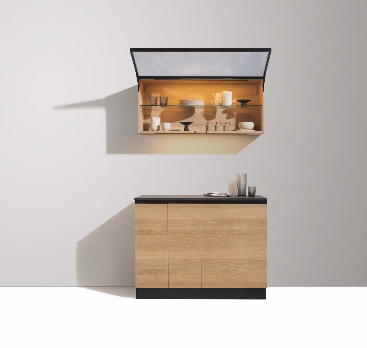 Fast grafisch wirken Sideboard und Vitrine zur Küche von Team 7. Perfekt zum Look ist die Farbe Schwarz.