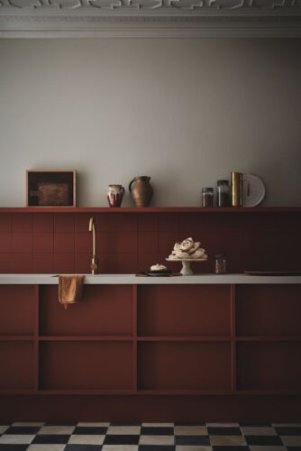 Die Küchenfronten und Rückwand tragen die schöne Herbstfarbe „Muscovado“ aus der Serie „Sweet Treats“ von Little Greene. Inspiriert ist das Erdrot von unraffiniertem Muscovado-Zucker. Gelungen ist das Wechselspiel von hervorstehenden und zurückweichenden, das wirkt lebendig.