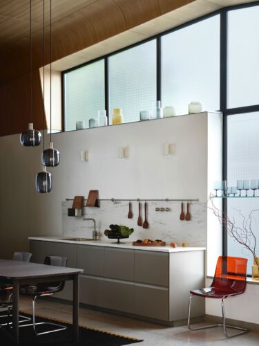 Die Fronten von Ikea sind super schlicht, aber nur auf den ersten Blick. Auf den zweiten haben sie eine hübsche Griffleiste, die an die Küchen der 70er Jahre erinnert. Die Lampen, Stühle und der Teppich harmonieren perfekt zum Look.