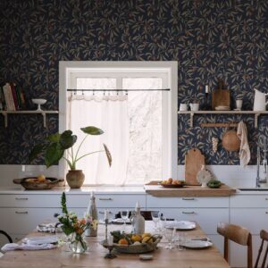 Im englischen Stil präsentiert sich die simple Küche. Das liegt an ein paar hübschen Einzelteilen und ebenso an der Vlies-Tapete „Vinnie“ in Nachtblau. Sie ist vom schwedischen Label Sandberg und sorgt für Wohnlichkeit. 