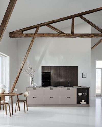 Eingefasst von Marmor, unterstützt von dunklem Holz – so präsentiert sich die Küche „Avolia“ in Beige von Kvik. Das wirkt ausdrucksstark.