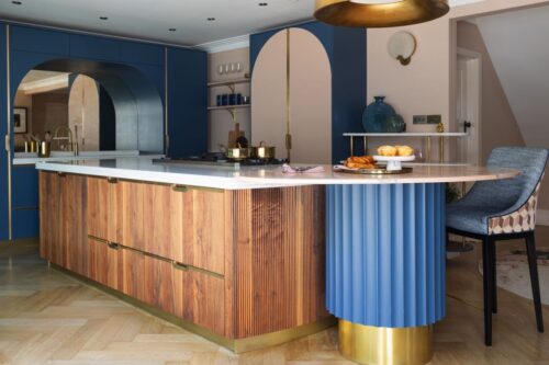Eine außergewöhnliche Küche, die wirkliche Individualität zeigt. Ein Mix aus Holz und Blau wirkt gemütlich und elegant zugleich. Super interessant ist der Tisch in seiner massiven Konstruktion. Küche „Abuja“ im Art Déco Stil von Wood Works Brighton. 