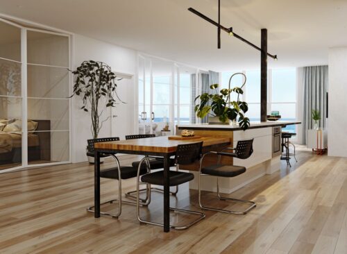 Im Zentrum dieses modernen Küchendesigns steht die großzügige weiße Kücheninsel, harmonisch erweitert durch einen stilvollen Holztisch mit markanten schwarzen Metallbeinen. Komfortable Sitzhocker an der Insel und elegante Freischwinger-Stühle am Tisch laden zum Verweilen ein. Das helle Parkett und bodentiefe Fenster unterstreichen die lichtdurchflutete Atmosphäre und setzen die Insel-Tisch-Kombination eindrucksvoll in Szene. Foto: Getty Images