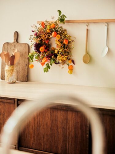 Im Herbst findet man viele Blumen in Orangetönen. Sie lassen sich lässig zu einem Kranz zusammenbinden. Die Farbe passt sehr gut in die Küche, denn sie hat eine positive Ausstrahlung und spendet schon beim Anblick neue Energie. So ein Kranz harmoniert zu einer Holzküche, egal ob die Fronten aus hellem oder dunklem Holz sind. Foto: Toll was Blumen machen
