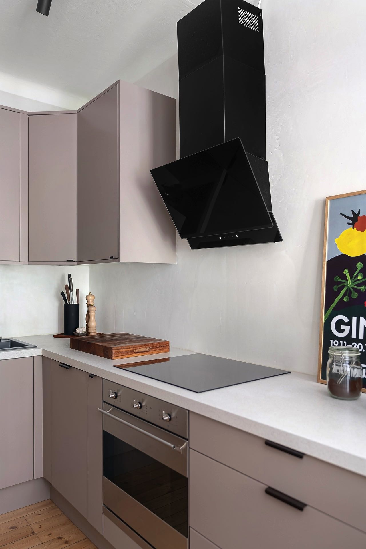 Ein moderner Touch in der Küche: Die elegante Kombination aus zarten Rosatönen und markantem Schwarz bei dieser Umlufthaube schafft einen ansprechenden Kontrast und unterstreicht das Designbewusstsein der Hausbesitzer.