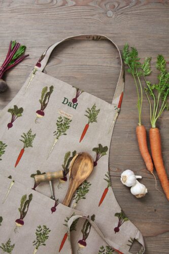 Damit beim Kochen auch alles stilvoll zueinander passt, ist eine hübsche Schürze toll, besonders wenn sie so dekorativ mit Gemüse verziert ist. Von Sophie Allport.