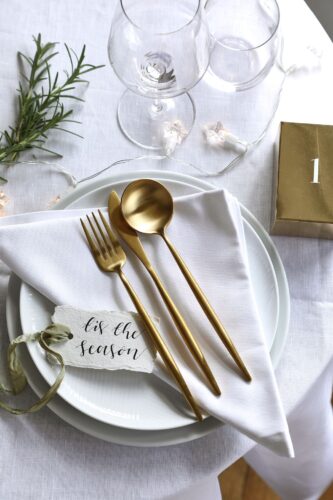 Weiß und Gold sind ein perfektes Paar. Super hochwertig präsentiert sich die Leinen-Serviette von The Fine Cotton Company. Attraktive Deko-Lösung: Eine Lichterkette über den Tisch legen, das wirkt gemütlich.