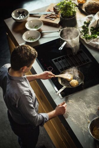 Eine optimale Arbeitshöhe am Induktionskochfeld ermöglicht, auch beim Kochen mit hohen Töpfen, eine gesunde Körperhaltung.