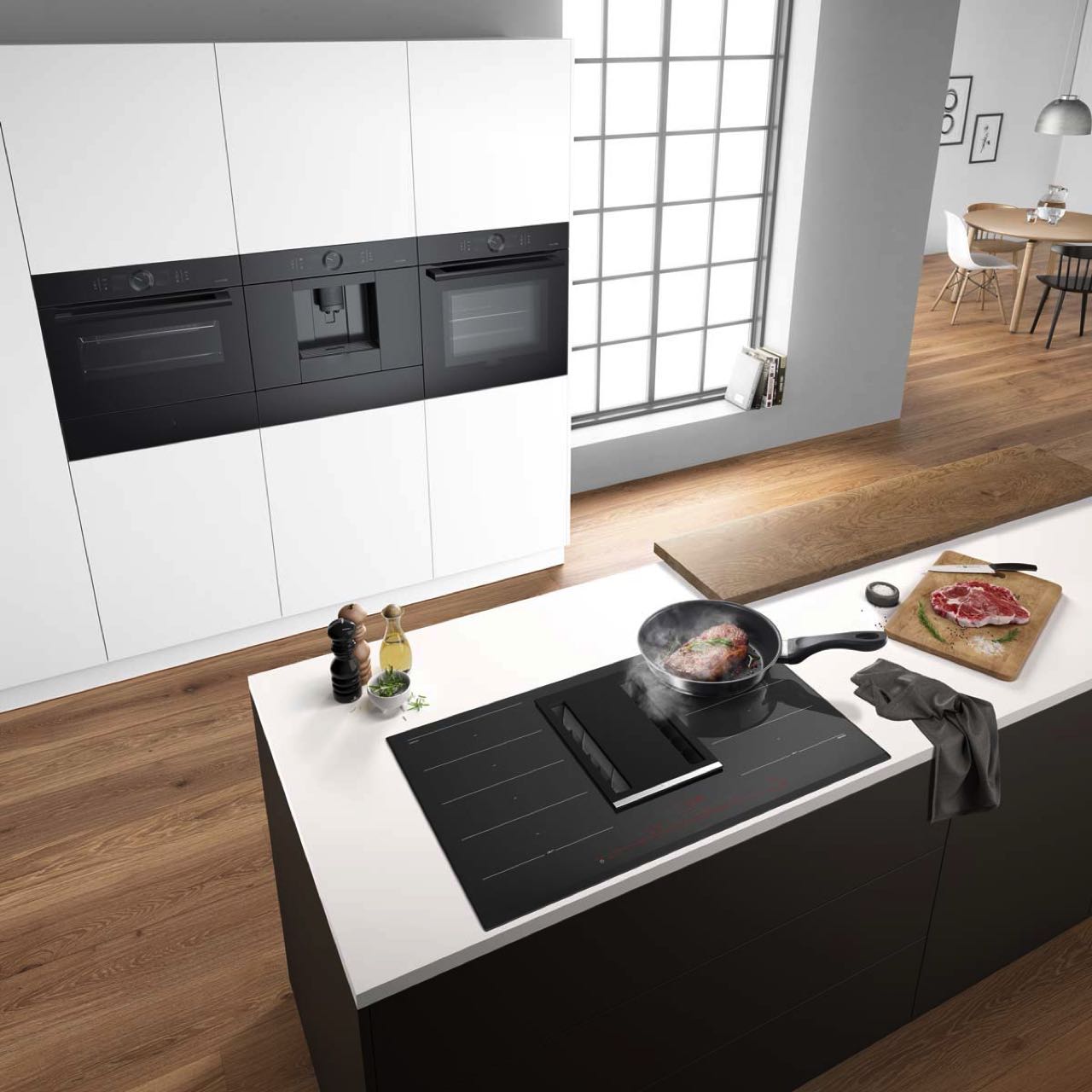 Die hochgesetzten Backöfen in dieser modernen Küchenzeile bieten einen ergonomischen Vorteil, da sie eine komfortable Bedienung auf Augenhöhe ermöglichen. Foto: AMK