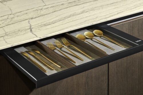 Der Hersteller SieMatic hatte eine ganz clevere Idee: Er nennt seine geheime Schublade „SecretService". Die flache Lade in der oberen Griffmulde wird mit der Push2Open-Technik geöffnet. Sie bietet Platz für Messersets, Käsehobel, Parmesanreibe. Sie ist unter anderem mit magnetischen Messerhaltern ausgestattet.