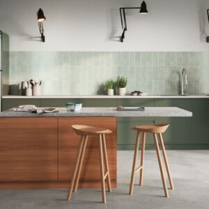 Die Farbe Salbeigrün ist ein Farbtupfer für die Küche. Dadurch bekommt der Raum eine mediterrane Note. Stilvoll sehen dazu die natürlich changierenden Fliesen von Agrob-Buchtal aus. Interessant ist die Anordnung, die hochkant und nicht quer ist.