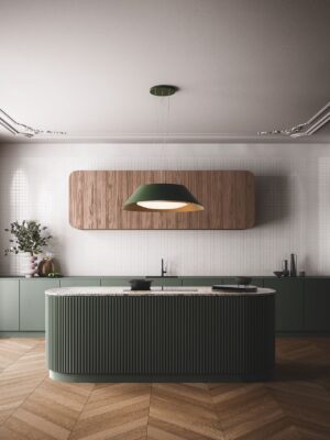 Die Kücheninsel sieht aus wie ein echtes Kunstwerk. Über ihr schwebt die Hightech-Dunstabzugshaube „Vogue“ von Falmec. Sie ist gleichzeitig eine Lampe. Die Form der Insel ergibt sich aus einzelnen Rundhölzern, die in angesagtem Grün strahlen. Das i-Tüpfelchen ist die Marmor-Platte.