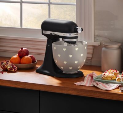 Die stilvolle Küchenmaschine von KitchenAid in mattem Schwarz mit dekorativer Keramikschüssel bringt Funktionalität und Design harmonisch zusammen und ist ein echter Hingucker auf jeder Arbeitsplatte.