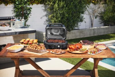 Der elektrische Grill „Woodfire“ von Ninja ist zugleich ein Smoker. Hier kann man grillen, räuchern, Heißluft frittieren. Das funktioniert mit Hilfe von Holzkohle Aromen, die man sieht und schmeckt. Sie befindet sich in der integrierten Smokerbox. 
