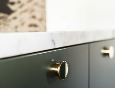 Neue Griffe können eine Küche erheblich aufwerten: Die abgebildeten eleganten, goldfarbenen Knöpfe verleihen den Schränken einen Hauch von Luxus und Modernität. Diese kleinen Details sorgen für eine frische und stilvolle Optik, die die gesamte Atmosphäre der Küche positiv beeinflusst.