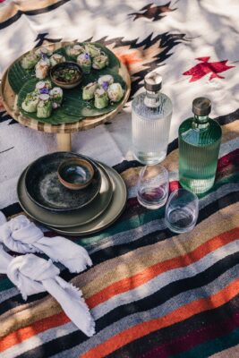 Ein Picknick ist eine herrliche Freizeitbeschäftigung. Dafür braucht man unbedingt eine schöne Decke. Optimal ist das Plaid mit dem für Mallorca bekannten Ikat-Zungenmuster und Streifen. Die verschließbaren Karaffen sind übrigens praktisch für unterwegs, von Paveau. 