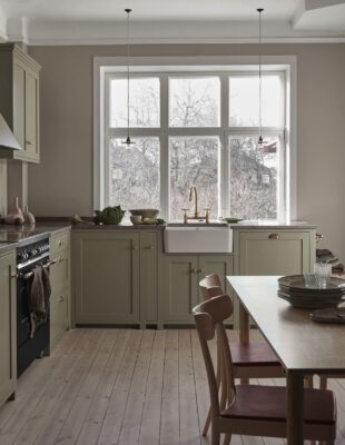 Das Besondere bei dieser Küche ist, dass die kürzere Zeile am Fenster steht. So hat man einen tollen Ausblick und die Optik wirkt leicht. Die Hauptzeile wird durch die Oberschränke erweitert. Die Shaker-Küche ist von Nordiska Kök.
