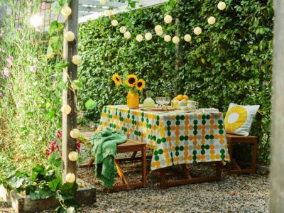 Gelb ist die Farbe der Sonne und des Sommers. Auch Sonnenblumen gehören einfach dazu und bringen neue Energie auf den Tisch. Wenn es heiß ist, ist es gut, sich so ein schattiges Plätzchen im Garten zu suchen. Schalen, Tassen und Tischdecke versprühen sommerlichen Charme mit ihrem grafischen Muster im Retro-Stil, von Ikea.