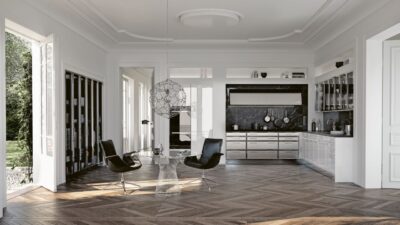Eingebaut in eine Nische ist die Küchenzeile aus der Serie „Classic“ von SieMatic. Dadurch tritt sie optisch zurück und lässt den sehr großen Raum noch ausladender erscheinen.