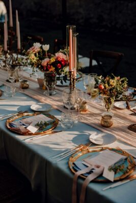 Eine stilvolle Tischdekoration, die durch goldene Akzente, zarte Pastelltöne und elegante Kerzenhalter besticht. Frische Blumenarrangements in herbstlichen Farben bringen Wärme und Lebendigkeit auf den Tisch, während feine Stoffe und dekorative Details für eine festliche Atmosphäre sorgen. Diese Kombination aus natürlichen Elementen und edlen Accessoires macht den Tisch zum Highlight eines jeden Herbstfestes im Freien. Foto: Patrick Langwallner on unsplash