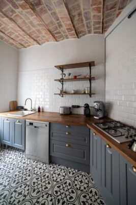 Rustikale Küche mit gemustertem Fliesenboden – Diese charmante Küche kombiniert einen klassischen Fliesenboden mit dunklen Holzarbeitsplatten und offenen Regalen für ein gemütliches Ambiente. Foto: Unsplash, Cihat Hıdır.
