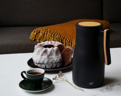 Filterkaffee dekorativ auf dem Kaffeetisch zu präsentieren, dafür eignet sich eine stylische Thermoskanne. Die schicke schwarze Kanne bekommt durch das gemütliche Holz einen ländlichen Charakter, von Alfi, ca. 100 Euro.