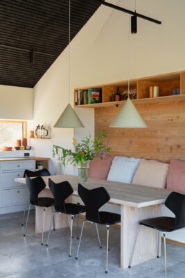 Kleinigkeiten beleben den Raum, auch die Kissen in soften Nuancen. Praktisch ist, dass sie immer entsprechend der Jahreszeit ausgetauscht werden können. Dieser Essbereich gehört zu einem Ferien-Cottage in Dänemark. Man kann es über Landfolk.com mieten.