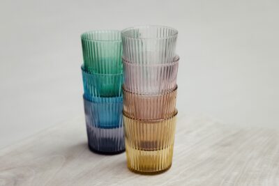Von den hübschen geriffelten Wassergläsern sind viele Farben erhältlich. Sie passen auf den stilvoll gedeckten Frühlingstisch und sind genau die richtige Wahl für Sprudel- oder Leitungswasser. Dazu gibt es eine farbige Glasflasche mit praktischem Deckel, alles von Paveau.