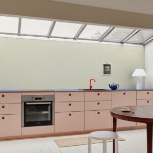 Rosa plus Blau? Das geht und sieht richtig kreativ aus. Auch der Raum als solches hat eine individuelle Note. Hübsch sind Akzente wie die orangefarbene Armatur oder die große Design-Leuchte. Küche aus der Serie „Basis“ von Reform.