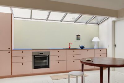 Rosa plus Blau? Das geht und sieht richtig kreativ aus. Auch der Raum als solches hat eine individuelle Note. Hübsch sind Akzente wie die orangefarbene Armatur oder die große Design-Leuchte. Küche aus der Serie „Basis“ von Reform.