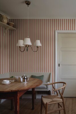 Mit Tapeten kann man den Look verändern. Holz und schlichte Farben sind zeitlos und recht neutral. Das verpasst dem Raum Country-Charme. Eine farbige Tapete lässt alles ein wenig mehr erstrahlen. Trotzdem ist sie mit dem Streifenmuster nicht zu aufdringlich. Tapete von Sandberg Wallpaper.