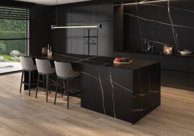 Auch dunkle Farben wirken sehr elegant und lassen das Gesamtbild extravagant aussehen. Schön ist hier die Einheitlichkeit von Wand und Möbeln. Die Marmorinsel und die Rückwand sind aus der Serie „Arklam“ von Tile of Spain im Farbton „Sahara Noir“.