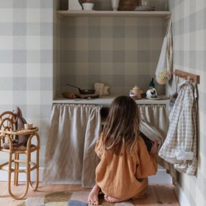 Im unteren Bereich der Küche dürfen nur Dinge aufbewahrt werden, die Kindern zugänglich gemacht werden sollen. Utensilien mit einem Vorhang zu verbergen ist sinnvoll, denn so kann sich keiner die Finger klemmen. Die hübsche Tapete ist von Sandberg.