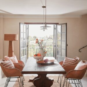 Ein Eyecatcher ist der massive Holztisch. Er ist groß und benötigt auf jeden Fall etwas Platz, dafür schafft man damit aber einen Ort, an dem alle zusammenkommen und sich wohlfühlen. Ähnliche Stücke lassen sich auf Antikmärkten finden. Die Rattanstühle ergänzen das Arrangement perfekt. Alles von Westwing.