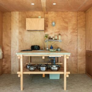 Holzfronten mit feiner Maserung bringen Wärme in den Raum und harmonieren wunderbar mit der reduzierten Gestaltung. Auch die ganz simple Kücheninsel hat Flair. Die Küche gehört zu einem Ferienhaus in Südfrankreich und kann über Landfolk gemietet werden.