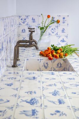 Die „Classic Delft Tiles“ sind außergewöhnlich für die moderne Küchengestaltung, aber sehr schick und extravagant. Sie verschönern Rückwand, Arbeitsfläche und Spülbecken. Die Anmutung der Fliesen und auch der geschwungenen Armatur wirkt antik, von Marlborough Tiles.