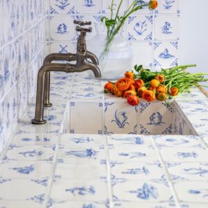 Die „Classic Delft Tiles“ sind außergewöhnlich für die moderne Küchengestaltung, aber sehr schick und extravagant. Sie verschönern Rückwand, Arbeitsfläche und Spülbecken. Die Anmutung der Fliesen und auch der geschwungenen Armatur wirkt antik, von Marlborough Tiles.