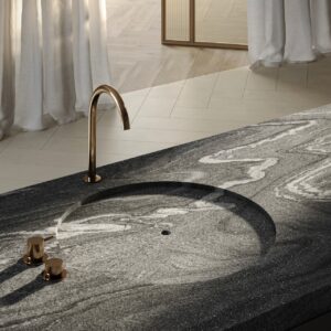 Ausgewählt wurde hier die Oberfläche “Silver Wave” mit ihrer elegant geschwun-genen Anmutung. Das flache Becken ist ideal, um Kleinigkeiten darin zu reinigen. Es verläuft nahtlos in die Arbeitsfläche. Eine sehr außergewöhnliche Idee von Sa-pienstone.

