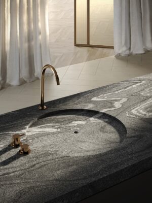 Ausgewählt wurde hier die Oberfläche “Silver Wave” mit ihrer elegant geschwun-genen Anmutung. Das flache Becken ist ideal, um Kleinigkeiten darin zu reinigen. Es verläuft nahtlos in die Arbeitsfläche. Eine sehr außergewöhnliche Idee von Sa-pienstone.

