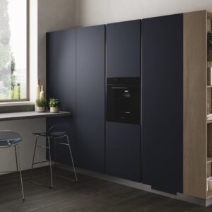 Die Konstruktion bietet ausreichend Stauraum mit hohen geschlossenen Schränken. Trotzdem präsentiert sich das Ganze nicht überladen. Das liegt daran, dass das helle Regal lebendig aussieht und die Einrichtung auflockert. Küche von Scavolini.

