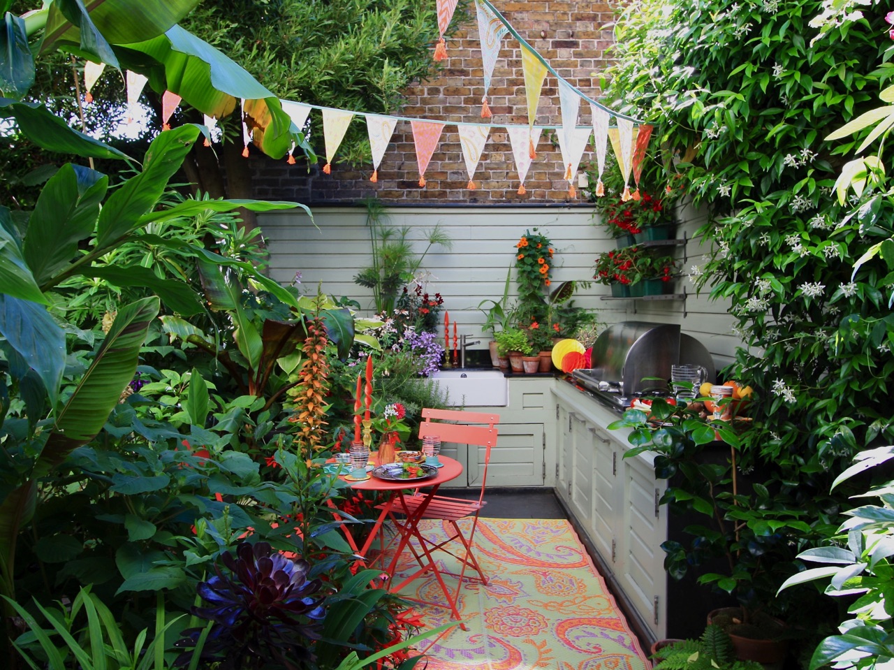 Wunderbar sind die Pflanzen in Kombination mit der Outdoor-Küche und dem Essplatz. Mut zur Farbe und liebevolle Deko-Elemente machen den Stil aus. Der hübsche Outdoor-Teppich ist von Talking Tables. | KÜCHEN JOURNAL Wunderbar sind die Pflanzen in Kombination mit der Outdoor-Küche und dem Essplatz. Mut zur Farbe und liebevolle Deko-Elemente machen den Stil aus. Der hübsche Outdoor-Teppich ist von Talking Tables.