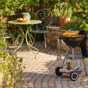 Der Kugel-Holzofengrill ist ein Klassiker. Er sieht dekorativ aus und passt zu jedem Gartenstil. Zusammen mit den schönen Vintage-Möbeln bildet er eine Einheit. Alles von Dobbies Garden Centres.