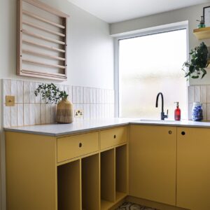 Die kleine Küchenzeile hat eine interessante Farbe und ebenfalls eine Form, die mal ein wenig anders ist. Die hohen Regalfächer bieten Platz für einzelne Töpfe oder gestapelte Teller. Die Küche ist von Wood Works Brighton.

