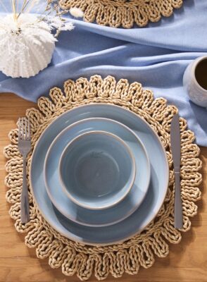 Lieblich verspielt kommt der gedeckte Tisch daher. Hell, freundlich und hyggelig wirken die Textilien, das Rattan-Tischset und das pastellige Keramikgeschirr, alles von B&M.