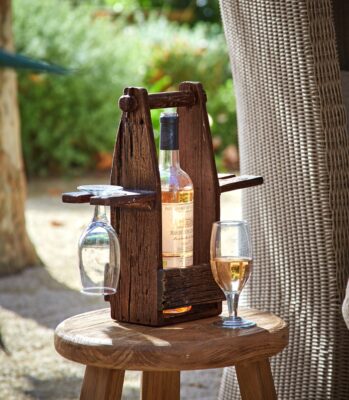 Der Flaschenhalter „Préalon“ mit Gläsern wird aus wiederaufbereitetem Holz gefertigt. Hübsch ist die authentische Maserung, von Loberon.