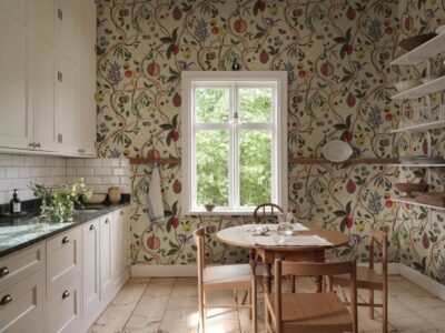 Südliches Urlaubsflair im mediterranen Look verströmt die Tapete „Tree of Life“ von Sandberg Wallpaper. Da die Küche leicht und hell wirkt und hohe Decken hat, ist es nicht überladen, zwei der Wände zu tapezieren.