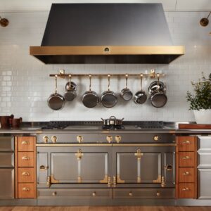 Keineswegs muss Edelstahl immer kühl wirken. Bester Beweis ist der tolle Range Cooker von La Cornue. Interessant ist, dass Gold und Holz dazu kombiniert werden, was den Look lieblich macht. Besonders sind die unterschiedlichen Kochzonen, hier lässt sich fast alles problemlos zubereiten. 