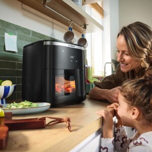 Air Fryer gibt es in unterschiedlichen Größen. Die „Air Fryer Serie 6“ von Bosch hat ein Fassungsvermögen von mehr als sieben Litern, perfekt für größere Familien mit bis zu fünf Personen. Hübsch sieht der beleuchtete Korb mit Sichtfenster aus. Dadurch ist der Garfortschritt jederzeit sichtbar, ohne dass man die Schublade öff-nen muss. So kann keine Hitze entweichen und es wird keine Energie verschwen-det. Sinnvoll ist der Signalton, der ertönt, wenn das Gargut gewendet werden sollte.